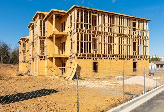 workers protected by temporary barrier fence during building maintenance in New Kingstown